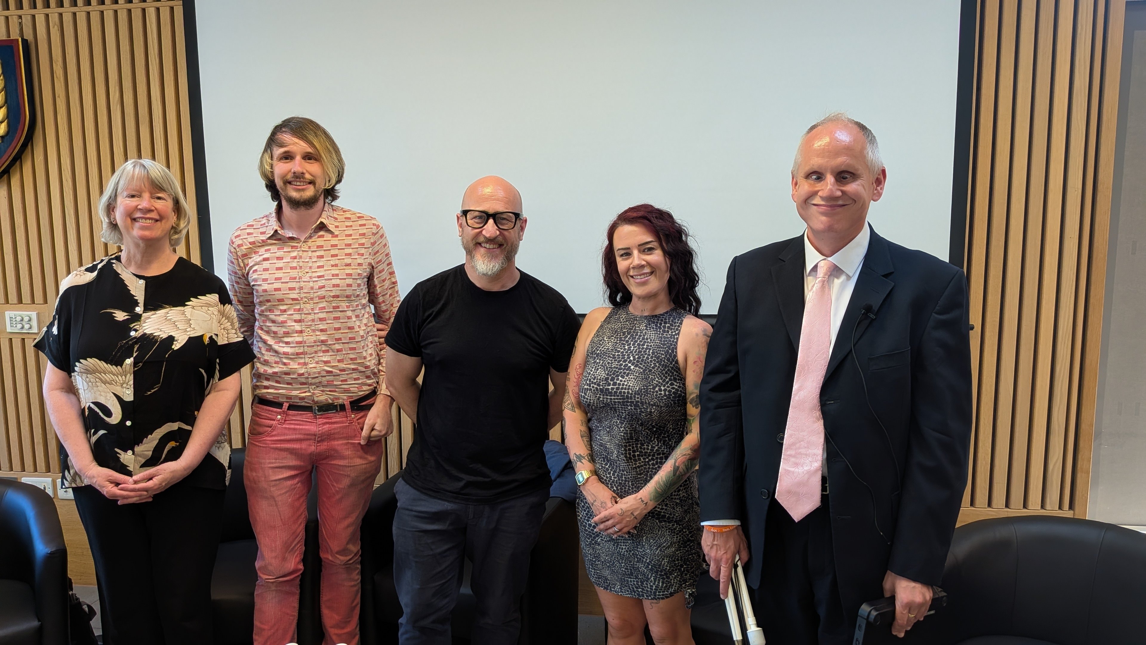 Panel stood and smiling for the camera